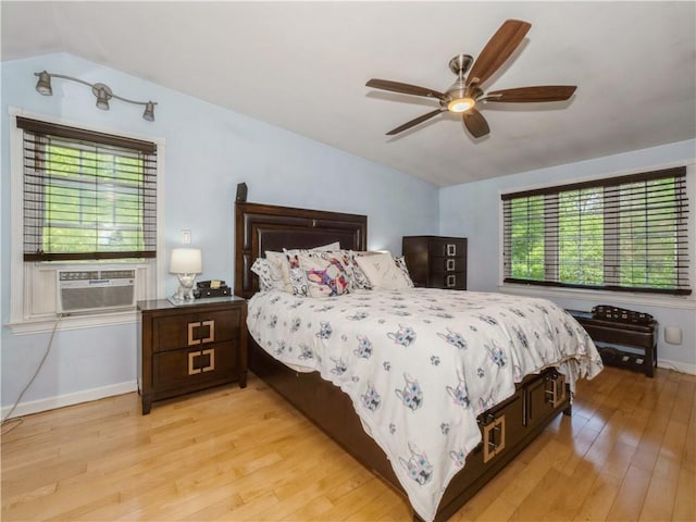 bedroom featuring multiple windows, ceiling fan, cooling unit, and light wood-type flooring