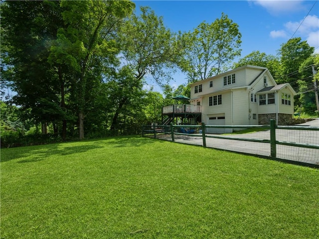 view of yard with a garage and a wooden deck