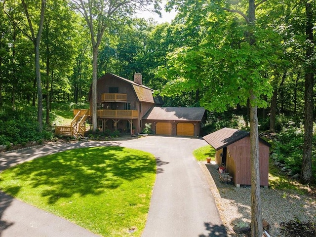 view of front of home featuring a front yard, a garage, and a storage unit