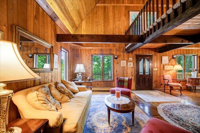 living room with hardwood / wood-style floors, wooden ceiling, high vaulted ceiling, wooden walls, and beam ceiling