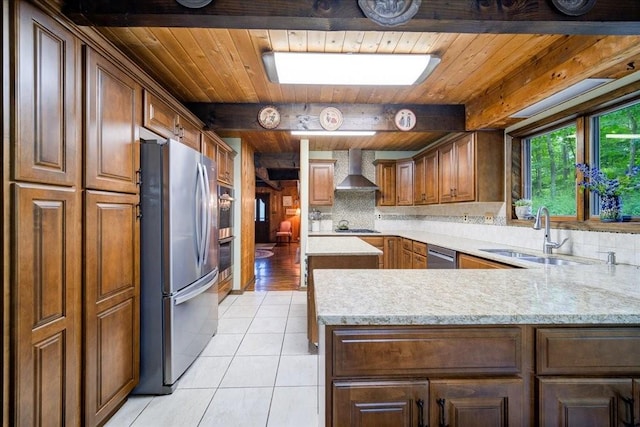 kitchen featuring kitchen peninsula, appliances with stainless steel finishes, wall chimney exhaust hood, sink, and light tile patterned floors