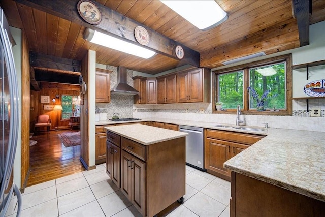 kitchen featuring sink, wall chimney range hood, light hardwood / wood-style flooring, a kitchen island, and appliances with stainless steel finishes