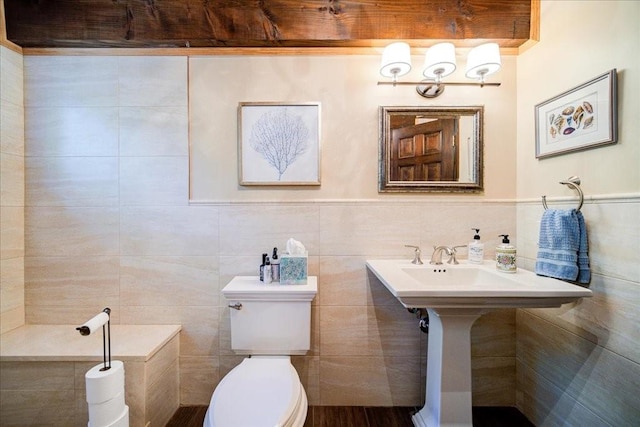 bathroom with toilet and tile walls