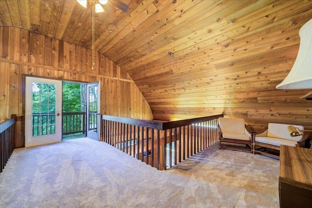 additional living space with ceiling fan, wooden ceiling, carpet floors, lofted ceiling, and wooden walls