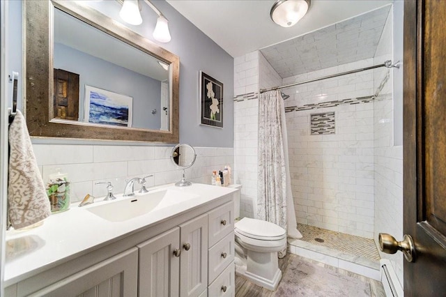 bathroom featuring vanity, a shower with curtain, toilet, baseboard heating, and tile walls