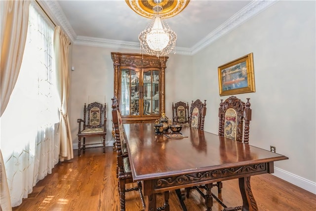 dining room with hardwood / wood-style flooring, crown molding, and a chandelier