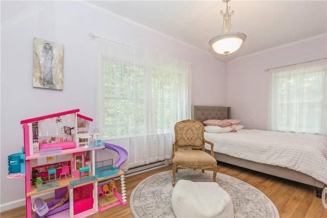 bedroom featuring hardwood / wood-style flooring, crown molding, a baseboard radiator, and multiple windows