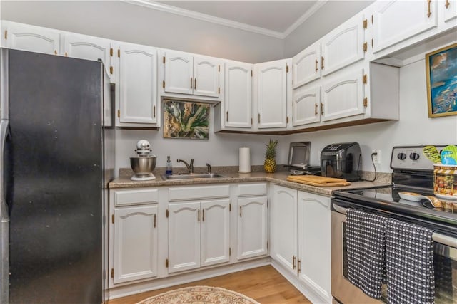 kitchen featuring electric range, sink, black fridge, and white cabinets