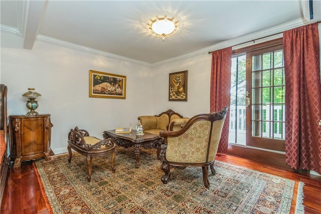 sitting room with beam ceiling, crown molding, and dark wood-type flooring