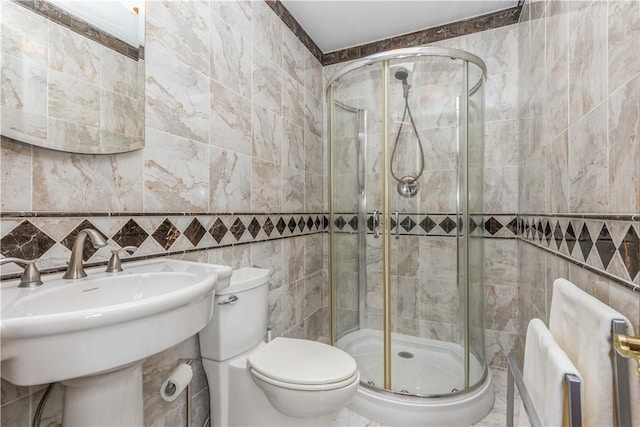 bathroom featuring sink, toilet, an enclosed shower, and tile walls