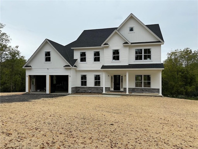 modern inspired farmhouse featuring covered porch and a garage