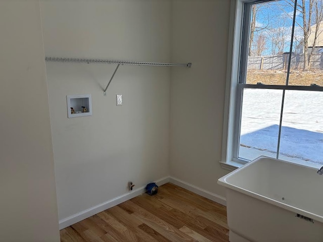 clothes washing area featuring hardwood / wood-style flooring, gas dryer hookup, and washer hookup