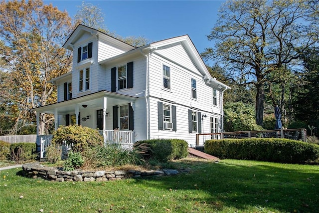 view of side of home featuring a porch and a yard