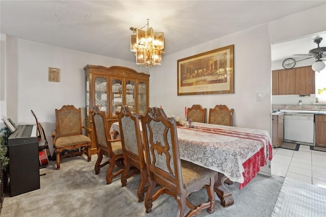 dining room featuring light colored carpet and ceiling fan with notable chandelier