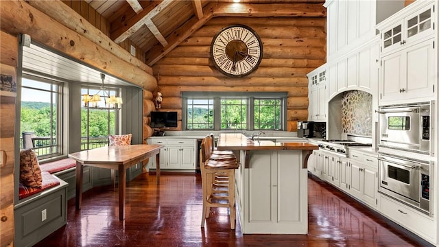 kitchen featuring a center island with sink, white cabinets, and plenty of natural light