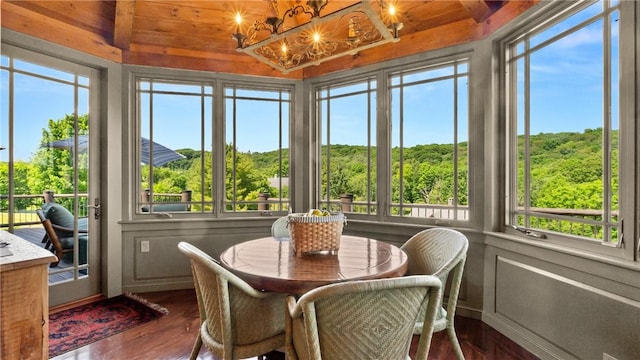 sunroom / solarium with a notable chandelier, lofted ceiling, and wooden ceiling