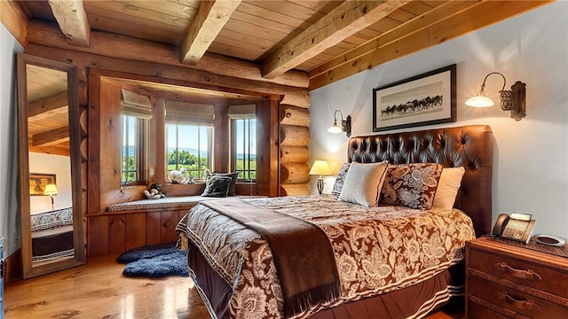 bedroom with beamed ceiling, log walls, light hardwood / wood-style floors, and wood ceiling