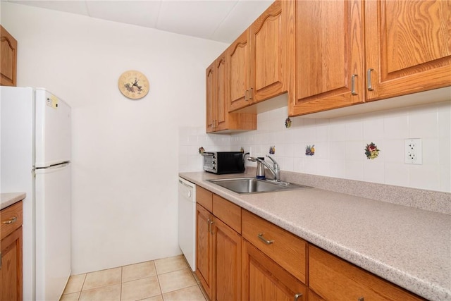 kitchen with backsplash, sink, light tile patterned floors, and white appliances