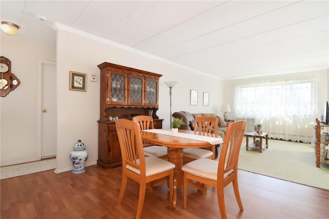 dining area featuring dark hardwood / wood-style flooring and ornamental molding