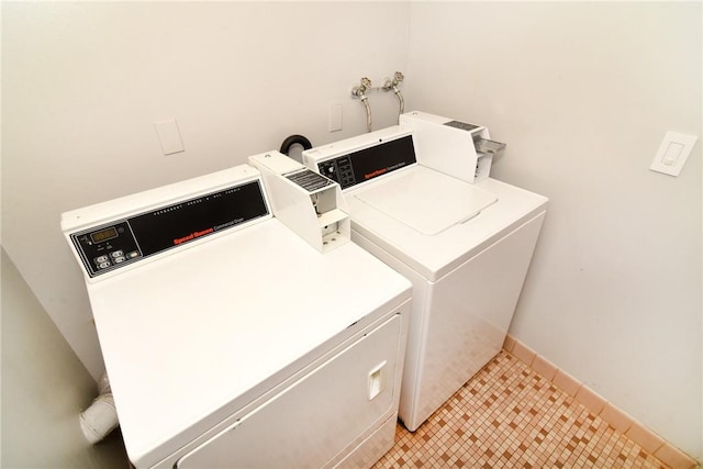 laundry area with independent washer and dryer and light tile patterned floors