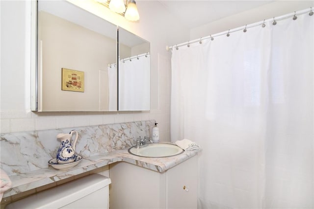 bathroom featuring tasteful backsplash, vanity, and toilet