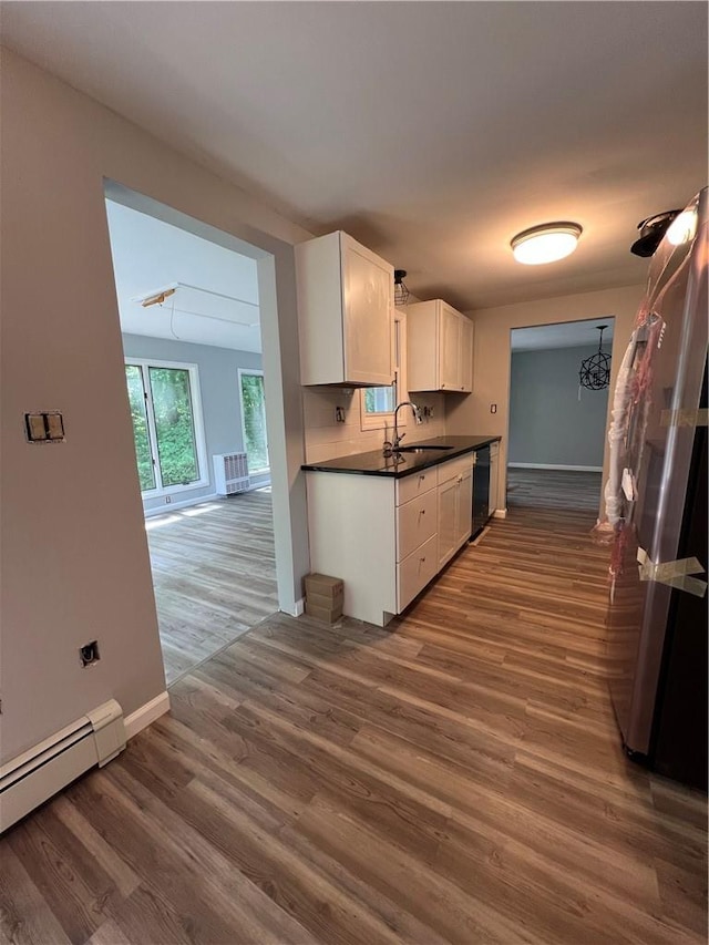 kitchen featuring sink, dark wood-type flooring, a baseboard radiator, black dishwasher, and white cabinets