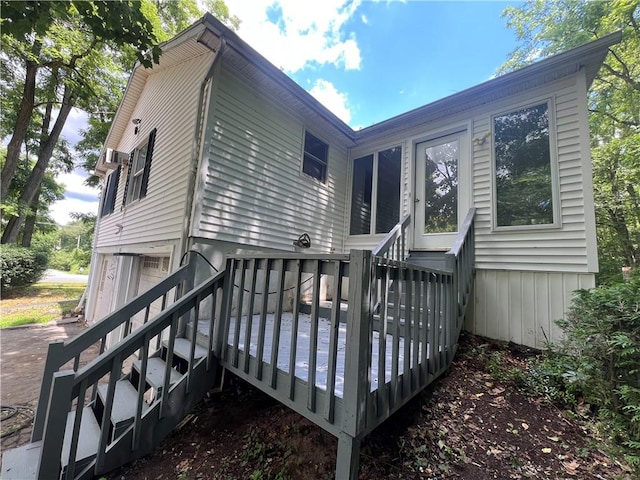 back of property featuring a garage and a wooden deck