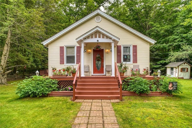 bungalow-style house featuring a front lawn and a storage shed