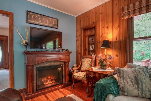 living area with wooden walls, light hardwood / wood-style flooring, and crown molding