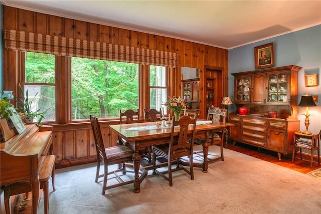 dining room featuring hardwood / wood-style floors, wooden walls, and ornamental molding