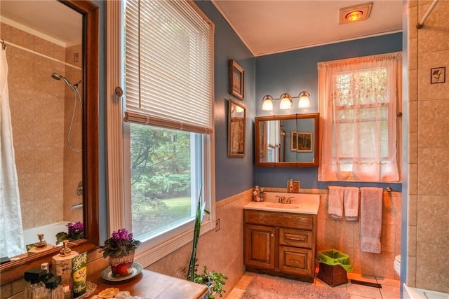 bathroom with tile patterned floors, vanity, tile walls, and toilet