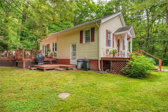 back of property featuring a wooden deck and a yard