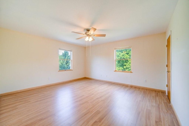 empty room with light wood-type flooring, a wealth of natural light, and ceiling fan