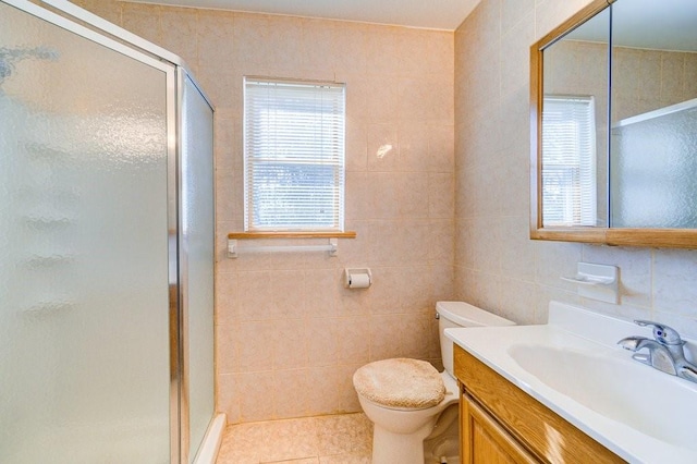 bathroom featuring tile patterned flooring, vanity, tile walls, and walk in shower