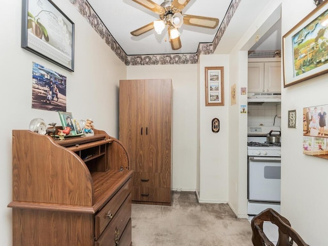 kitchen featuring decorative backsplash, ceiling fan, light colored carpet, and white range with gas stovetop