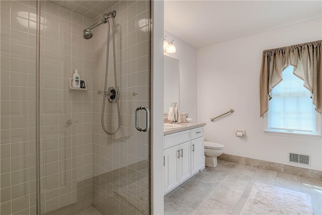 bathroom featuring toilet, vanity, and a shower with door