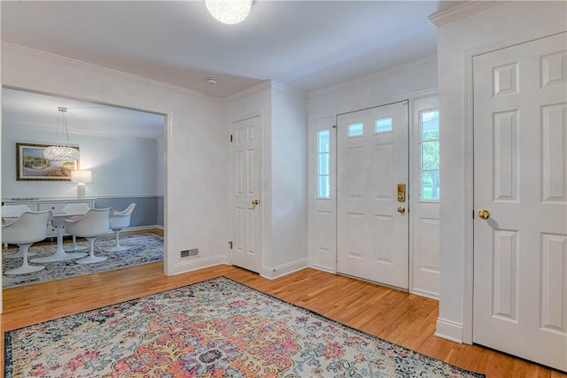 foyer featuring light hardwood / wood-style flooring and crown molding