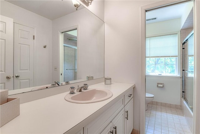 full bathroom with toilet, tile patterned floors, vanity, and enclosed tub / shower combo