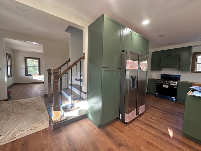 kitchen featuring custom exhaust hood, green cabinets, stainless steel appliances, dark wood finished floors, and recessed lighting