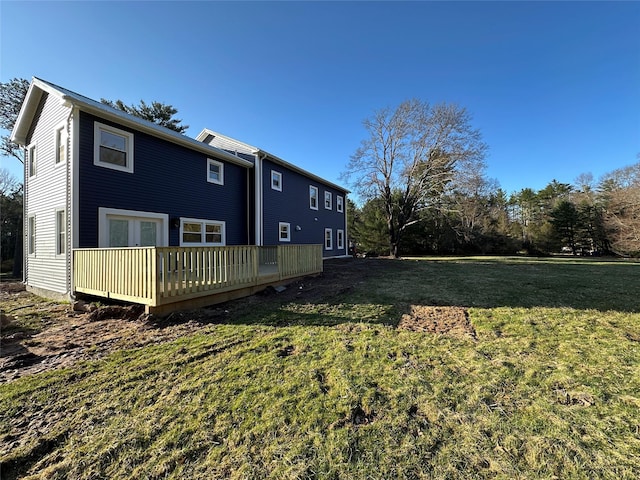 back of house featuring a lawn, a deck, and french doors