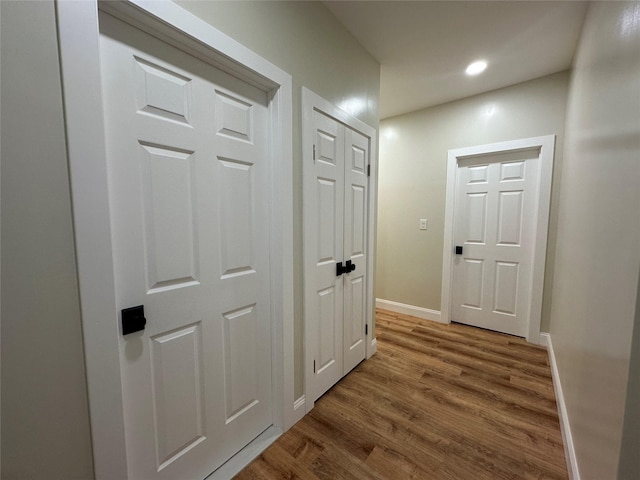 corridor with recessed lighting, wood finished floors, and baseboards