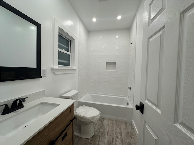 bathroom featuring wood finished floors, vanity, shower / tub combination, toilet, and recessed lighting