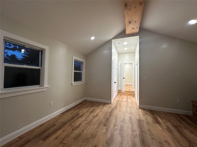 empty room with lofted ceiling, baseboards, wood finished floors, and recessed lighting