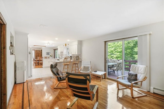 living area with light wood-type flooring and baseboard heating