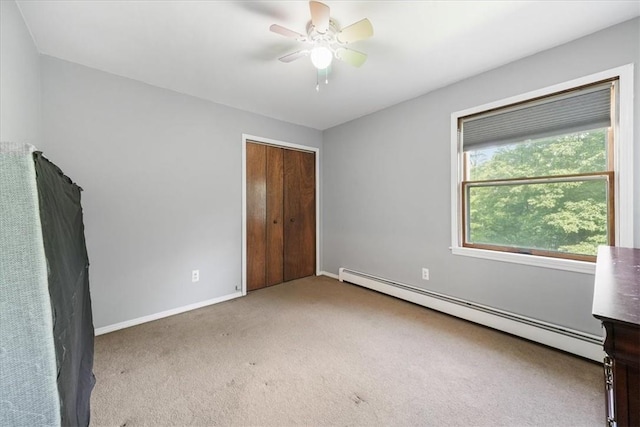 unfurnished bedroom featuring carpet flooring, ceiling fan, a closet, and a baseboard radiator