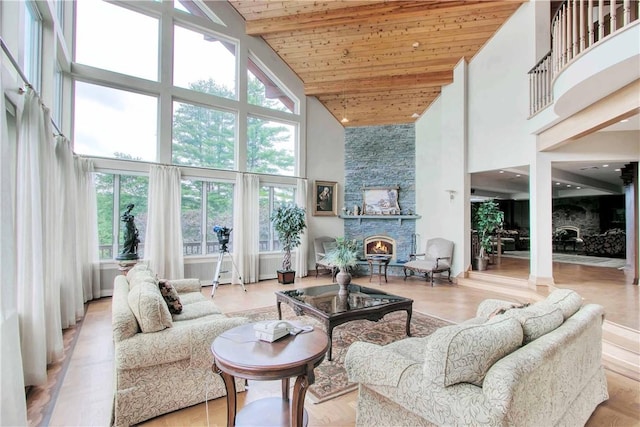 living room with a fireplace, high vaulted ceiling, and wooden ceiling