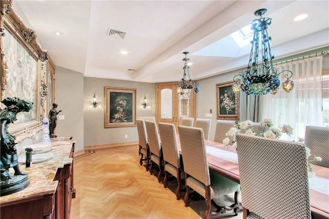 dining space featuring light parquet floors and a skylight