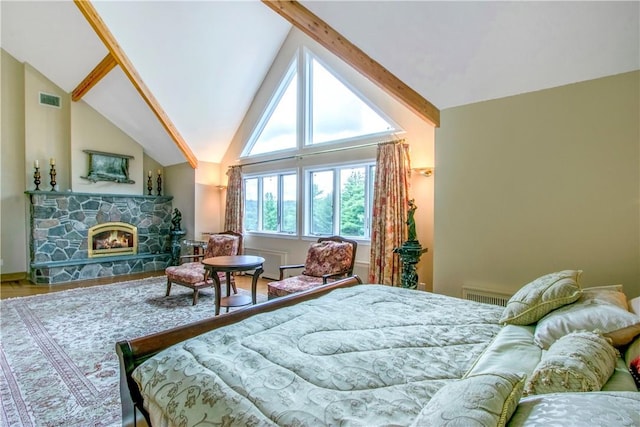 bedroom with lofted ceiling and a stone fireplace