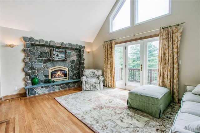 living room with hardwood / wood-style flooring, a fireplace, and high vaulted ceiling