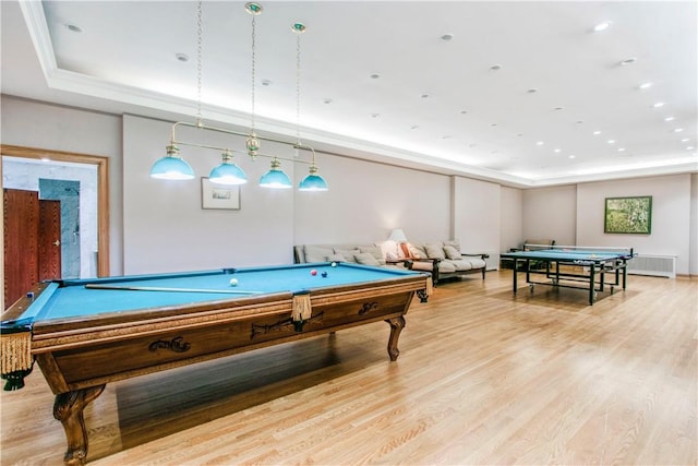 game room featuring a raised ceiling, ornamental molding, light hardwood / wood-style floors, and billiards